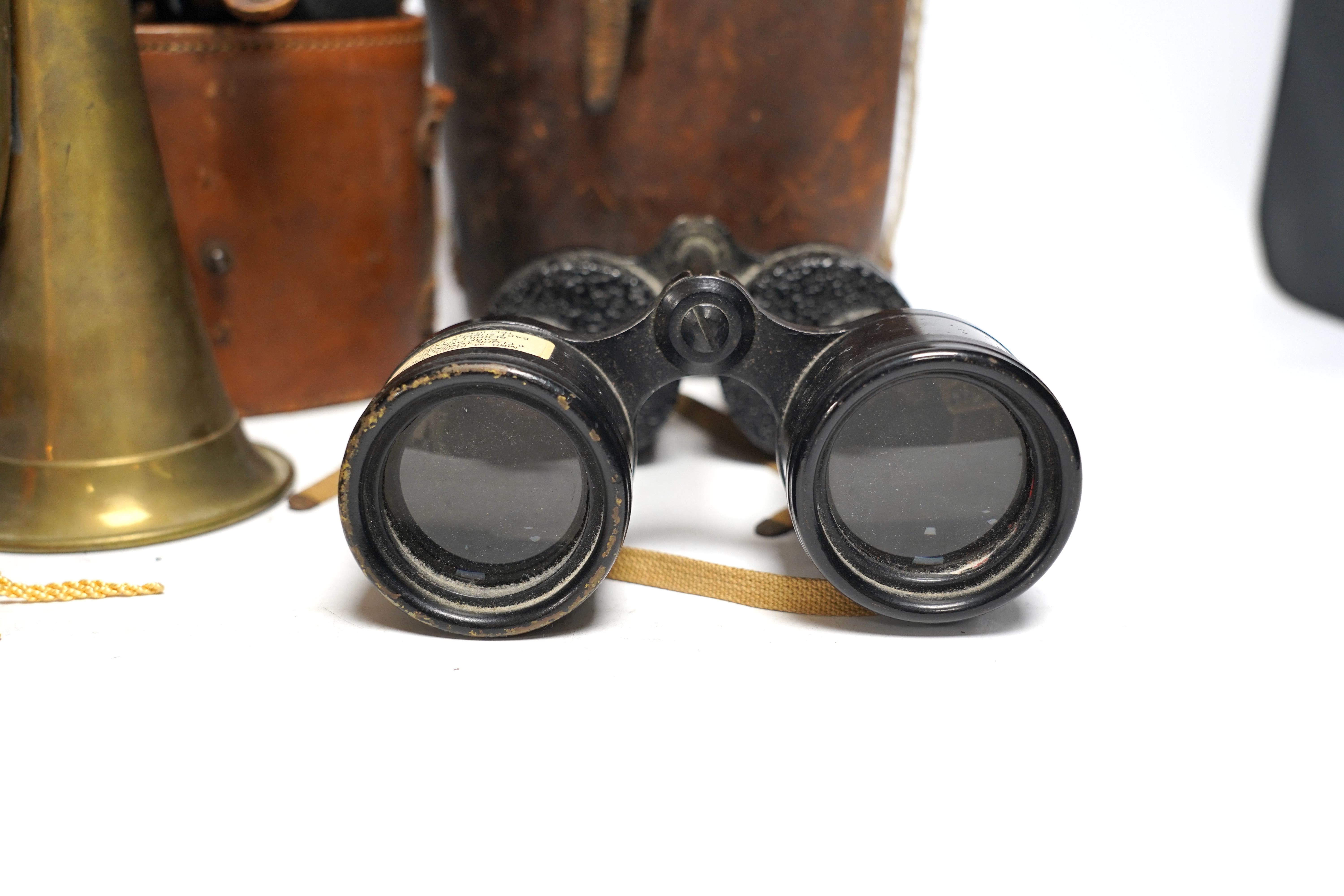 Two cased pairs of binoculars and a brass bugle.